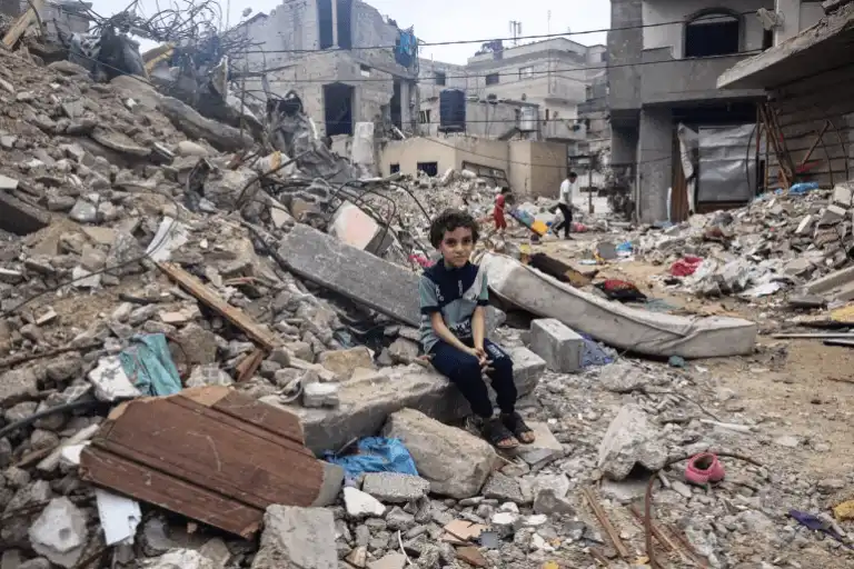 a child sitting on a pile of rubble description a child sitting on a pile of rubble description