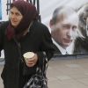 Водка, 'Калинка' и русская душа (Пожилая женщина на фоне плаката с Владимиром Путиным в Санкт-Петербурге | © AP Photo, Dmitry Lovetsky) Пожилая женщина на ф…
