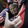 Atlantic (США): Когда Америке придет конец (Женщина держит телефон с фотографией Дональда Трампа во время предвыборной кампании в США | © AP Pho…) Женщина держит телеф…