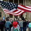 В США вводят сексуальную привилегию (Женщина машет флагом США у Капитолия штата Мичиган в Лансинге | © AFP 2021 / Nic Antaya) Женщина машет флагом…